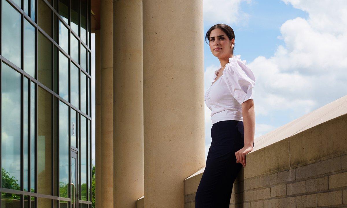 A student leaning on a wall outside